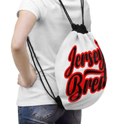 This is a mock up of the Jersey Bred drawstring bag on the back of a person wearing jeans and a white t shirt.
